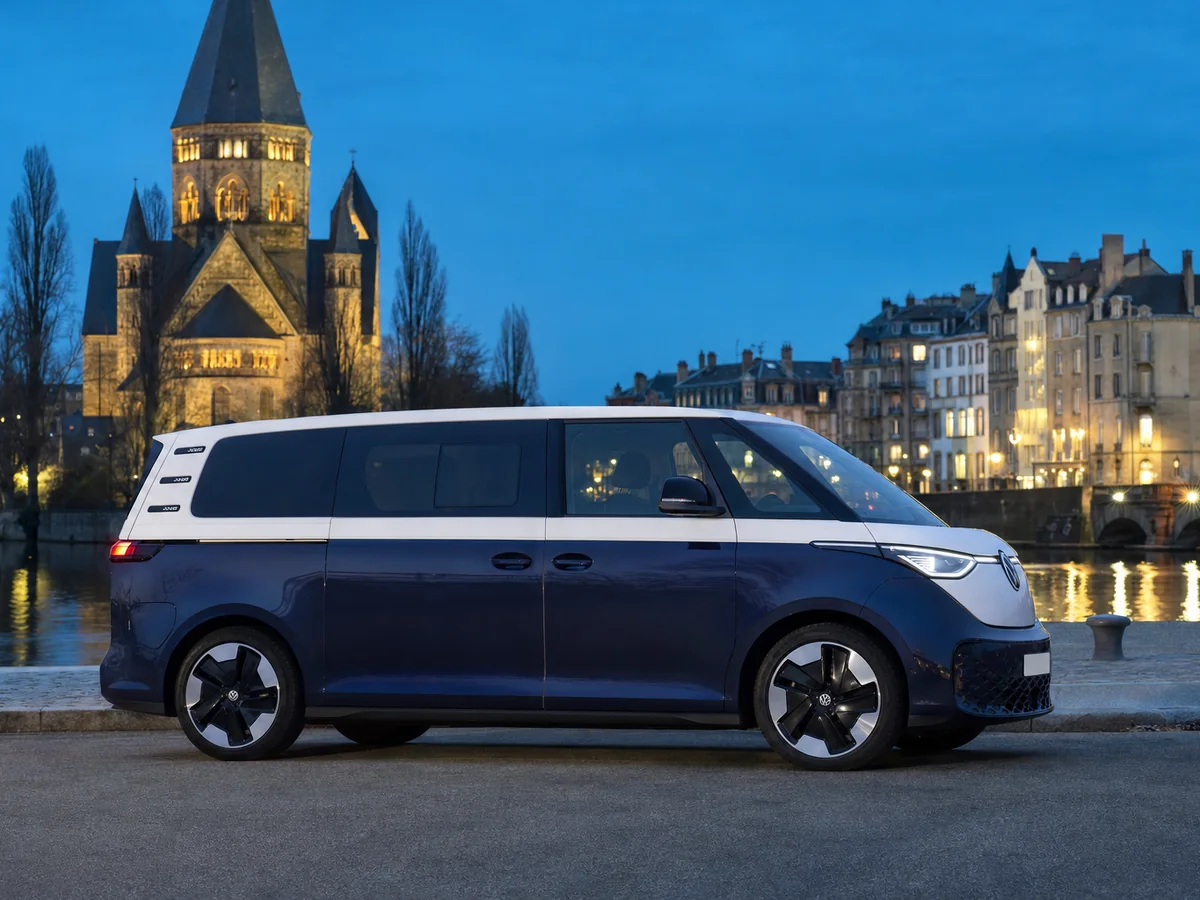 Volkswagen ID. Buzz bicolore blanc et bleu de profil sur les quais de la Moselle à Metz — van électrique 6 places, Didier VTC Metz